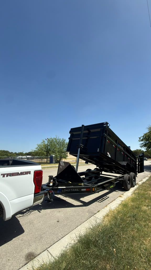 The truck and dump trailer parked at the curb
